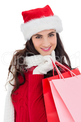 Cheerful brunette in winter wear holding shopping bags