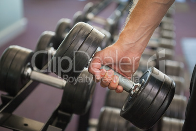 Close up of hand holding dumbbell in gym