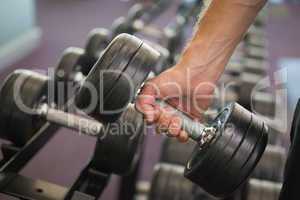 Close up of hand holding dumbbell in gym