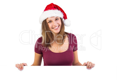 Festive brunette smiling at camera holding poster