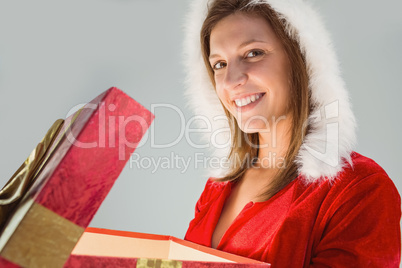 Smiling girl opening a gift and looking at the camera
