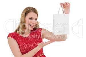 Smiling woman presenting a shopping bag