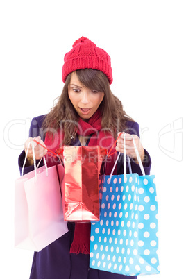 Shocked brunette opening gift bag