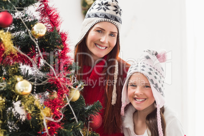 Mother and daughter decorating christmas tree