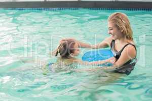 Happy mother and daughter in the swimming pool