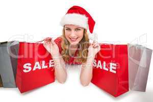 Smiling woman lying between sale shopping bags