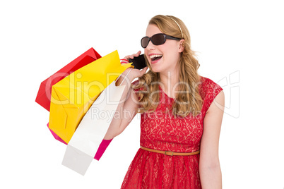 Pretty blonde talking on phone holding shopping bags