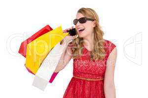 Pretty blonde talking on phone holding shopping bags