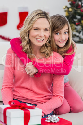 Festive mother and daughter smiling at camera