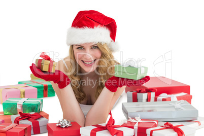 Woman in santa hat laying on the floor while holding gifts