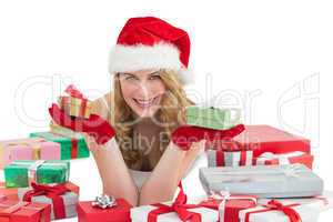 Woman in santa hat laying on the floor while holding gifts