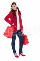 Cheerful brunette in winter clothes posing and holding shopping