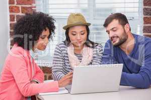 Creative team using laptop in meeting