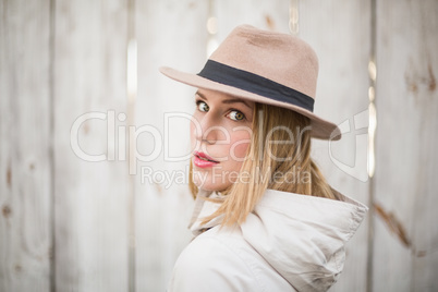 Pretty blonde woman with hat looking over her shoulder