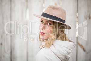 Pretty blonde woman with hat looking over her shoulder