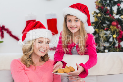 Festive mother and daughter with plate of cookies