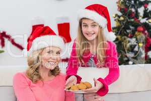 Festive mother and daughter with plate of cookies