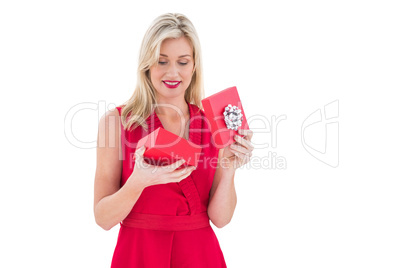 Stylish blonde in red dress opening gift box