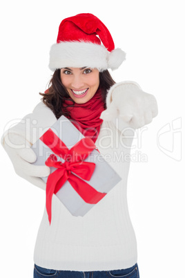 Excited brunette in santa hat giving gift