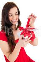 Happy brunette sitting and opening gift