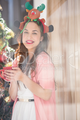 Brunette in christmas hat holding mug