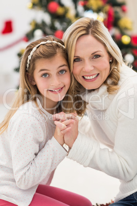 Festive mother and daughter beside christmas tree