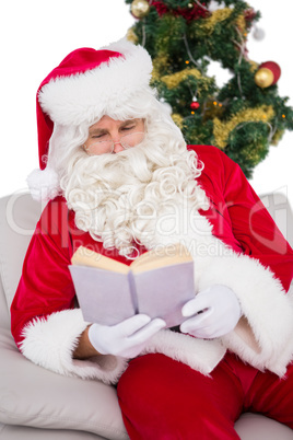 Relaxed santa reading on the couch