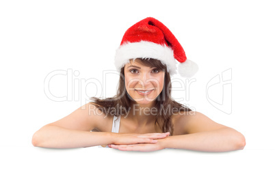 Festive brunette leaning on large poster