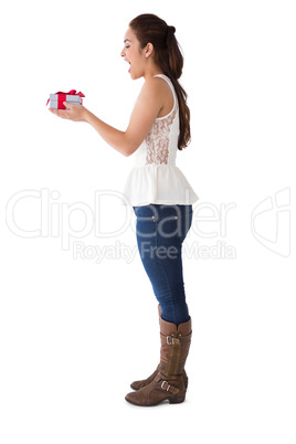 Surprised brunette holding a present