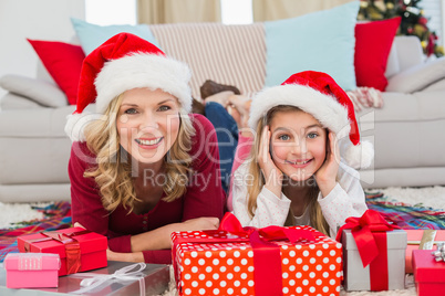 Festive little girl with mother surrounded by gifts