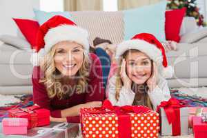 Festive little girl with mother surrounded by gifts