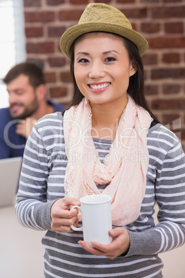 Casual woman with coffee cup in office