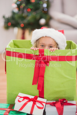 Cute little girl sitting in giant christmas gift