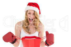 Shocked blonde opening a shopping bag with boxing gloves