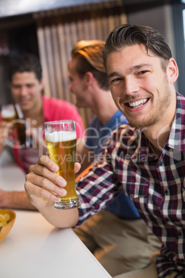 Young man holding pint of beer