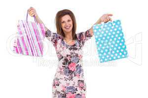 Young woman in floral dress holding up shopping bags