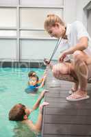 Pretty swimming coach showing boy his time