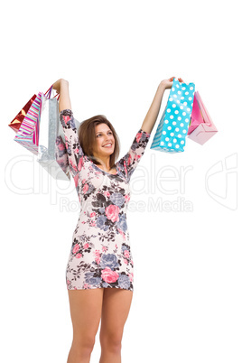 Excited brunette holding up shopping bags