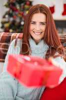 Festive redhead with gift on the couch