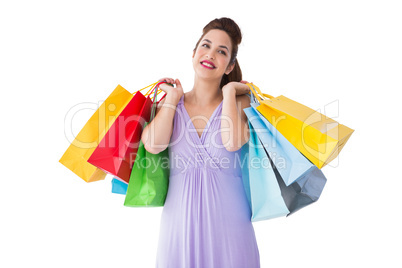 Thoughtful brunette holding shopping bags