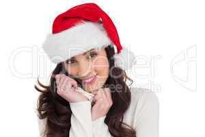 Beautiful brunette in santa hat smiling at camera
