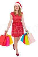 Pretty woman in santa hat standing with shopping bags