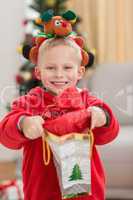 Festive little boy smiling at camera with gift