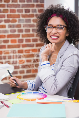 Smiling female photo editor using digitizer in office