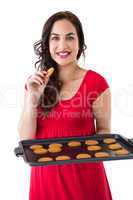 Smiling blonde eating hot cookies