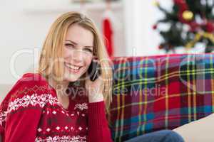 Happy woman relaxing on couch talking on phone