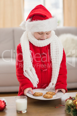 Festive little boy holding plate of cookies