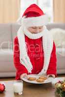 Festive little boy holding plate of cookies
