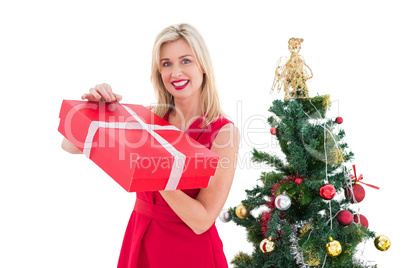 Festive blonde in red dress holding gift