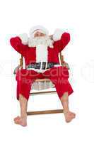 Happy santa relaxing on deckchair